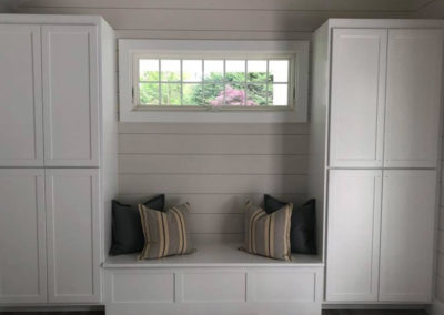 picture of white tall cabinets and white sitting bench