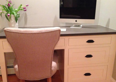 picture of a small desk with a light pink chair