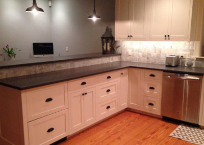 picture of kitchen with white cabinets and dark granite countertops
