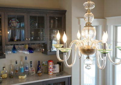 picture of chandelier and the kitchen bar behind-ocean getaway
