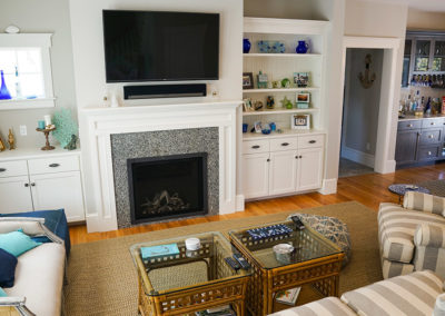 picture of a fire place and a T.V. above it with shelving on either side-ocean getaway