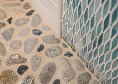 picture of pebble floor and mosaic wall in shower- ocean getaway