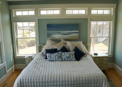 picture of bed with ocean picture hanging on the wall- ocean getaway