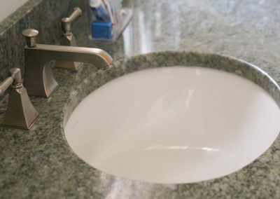 picture of a sink in the green granite countertop- cape seashore home