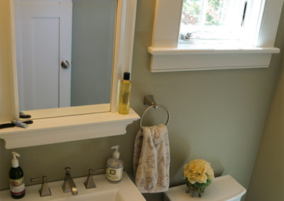 picture of a small vanity and mirror and toilet- cape seashore home