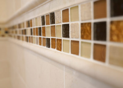 picture of natural colored mosaics in tiles on the walls of the bathtub- cape seashore home