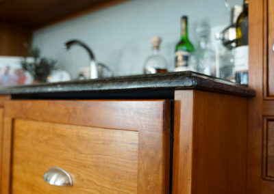 picture of wooden kitchen cabinets with a granite countertop- cape seashore home