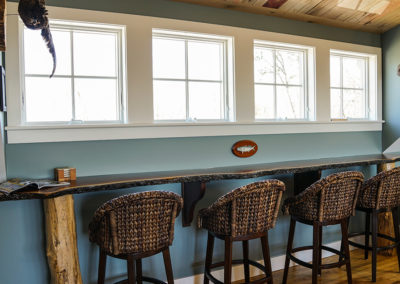 picture of wooden table and wicker chairs with 4 windows above- cape seashore home