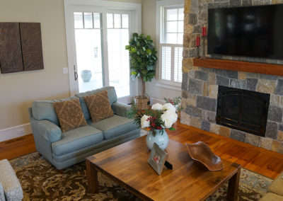 picture of living room with couches and a fireplace and television- cape seashore home