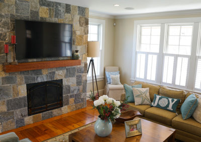 picture of living room with couches and a fireplace and television- cape seashore home